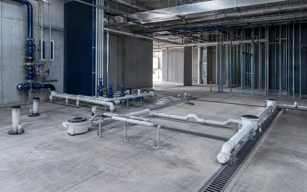 Commercial drainage pipework installed across a clean concrete construction floor