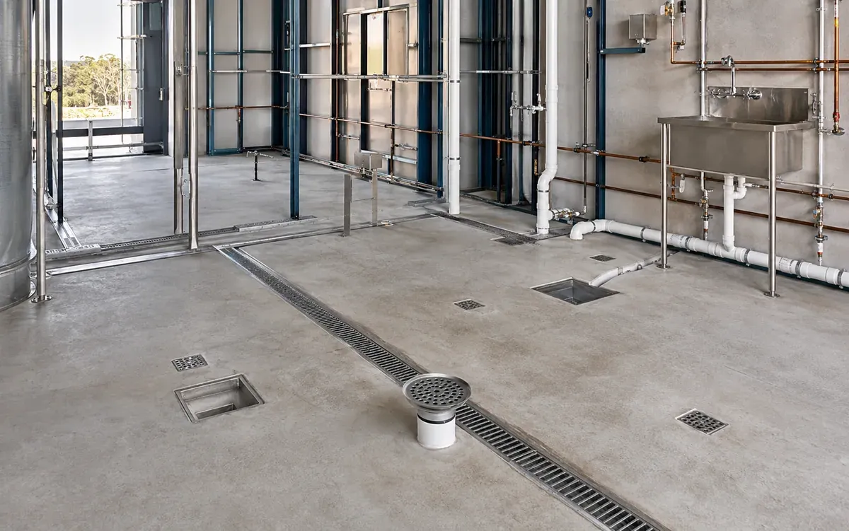 Commercial trade waste floor drains and pipework in an industrial service area