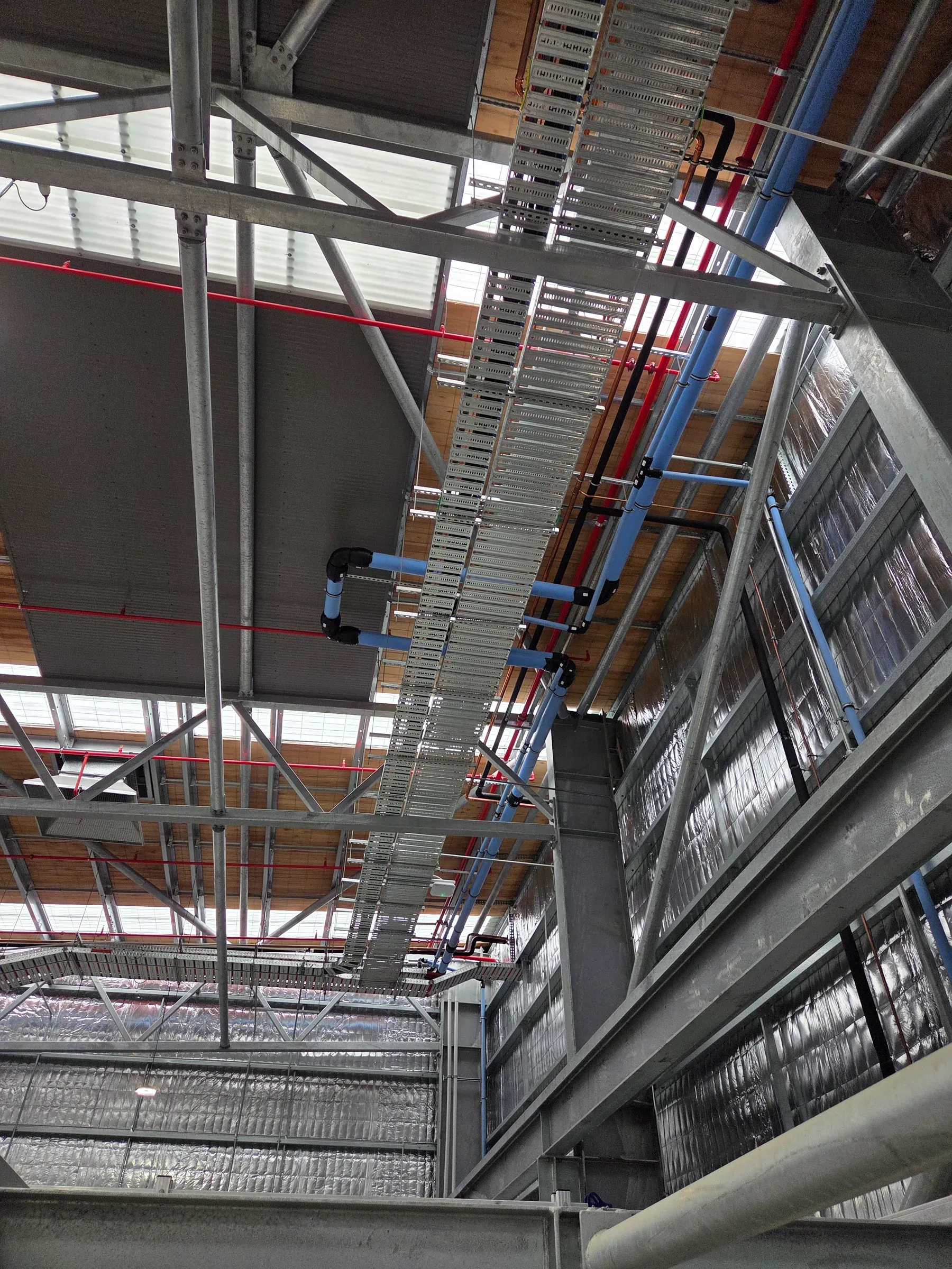 Blue hydraulic service pipe installed through a commercial building structure